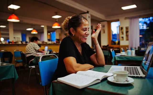Dona de pequeno negócio sorrindo durante uma videochamada no notebook