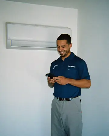 Técnico de ar-condicionado lendo uma mensagem no celular durante um atendimento